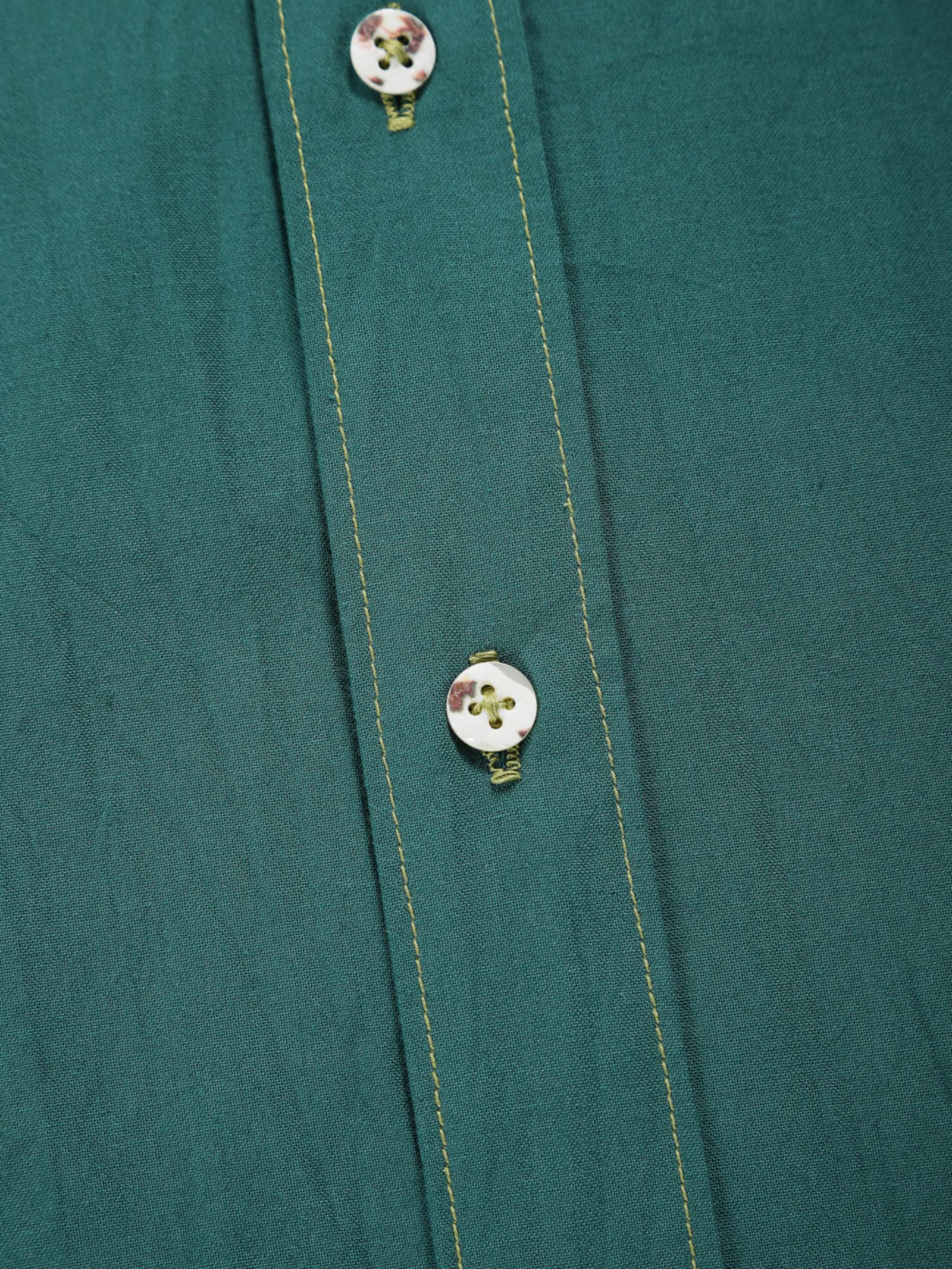 Close-up of old forest plant-dyed organic cotton shirt placket with natural shell buttons and contrast stitching.