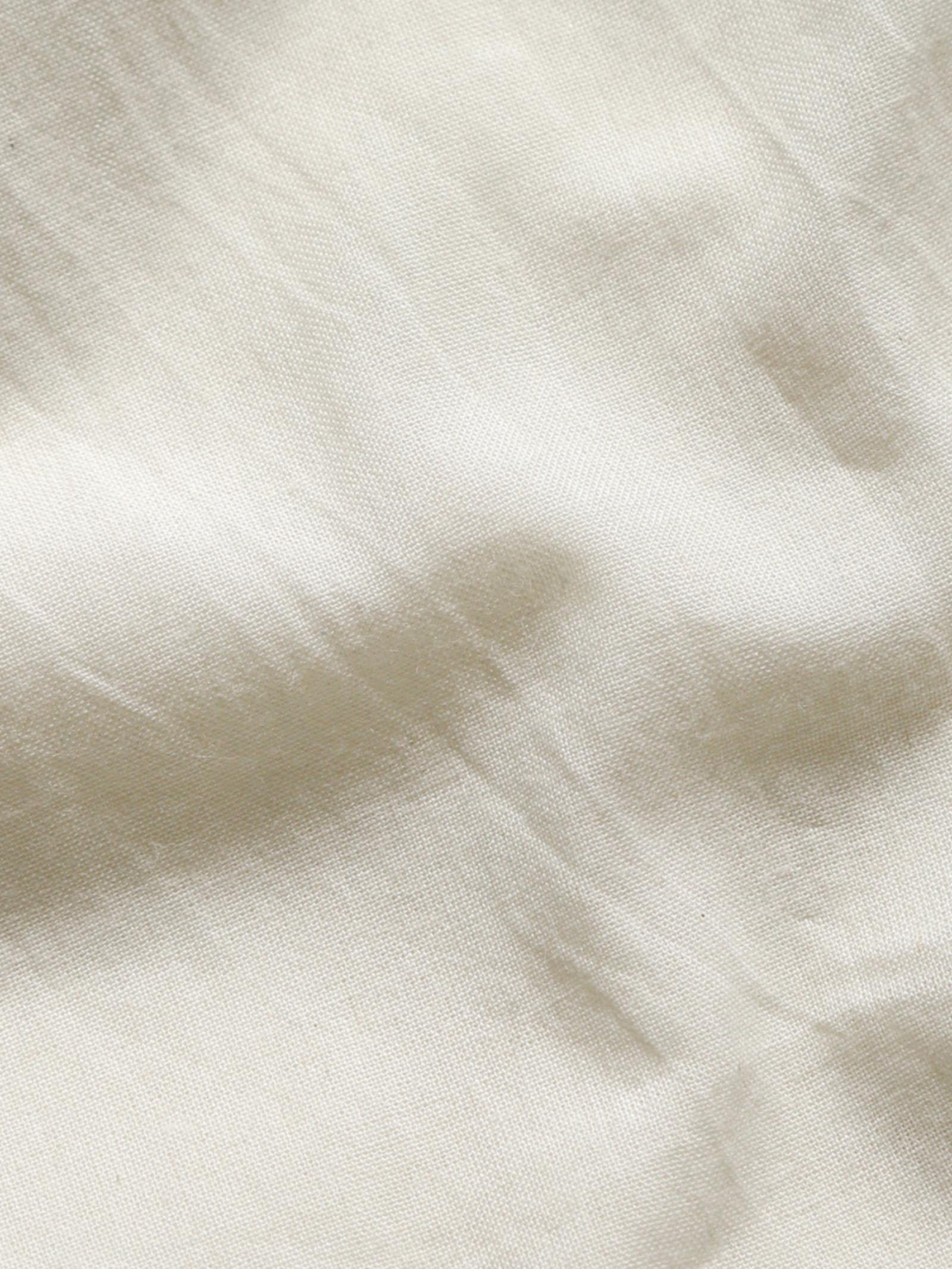 Close-up of undyed organic cotton fabric showing natural texture and weave.