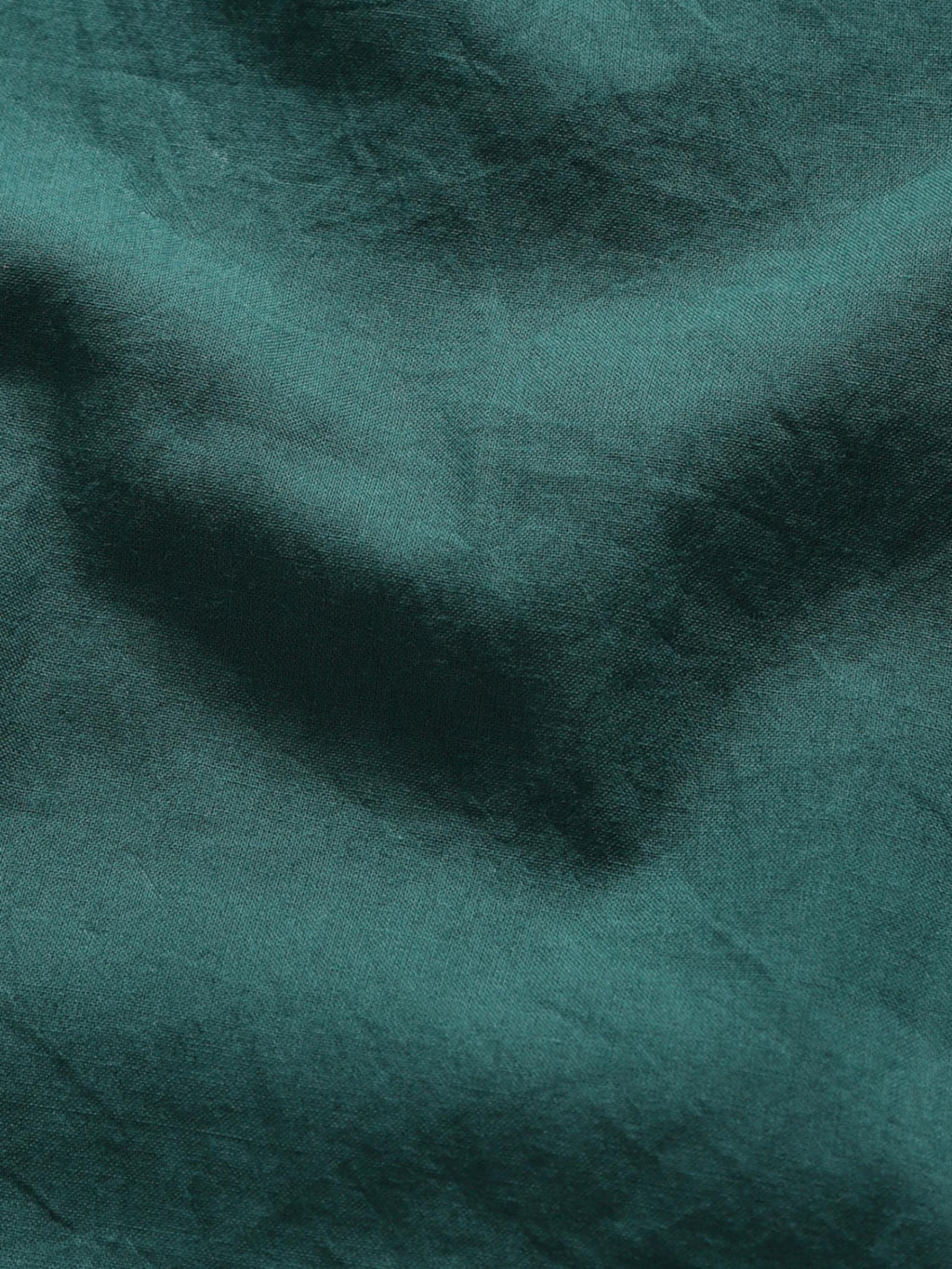 Close-up of old forest plant-dyed organic cotton fabric showing natural texture and weave.